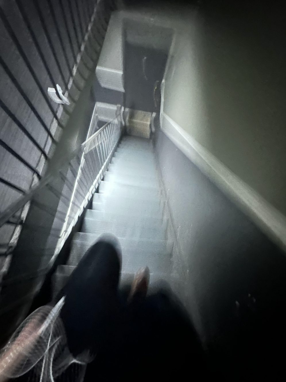 blurry stairwell looking down, feet visible